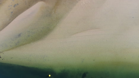 overhead view of clear water over golden sand on the coastline of st kilda, melbourne, australia