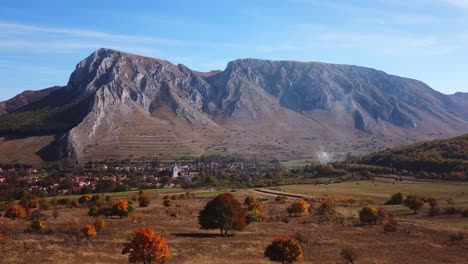 Forward-drone-shot-of-Rimetea-and-mount-Szekelyko,-on-a-sunny-autumn-day