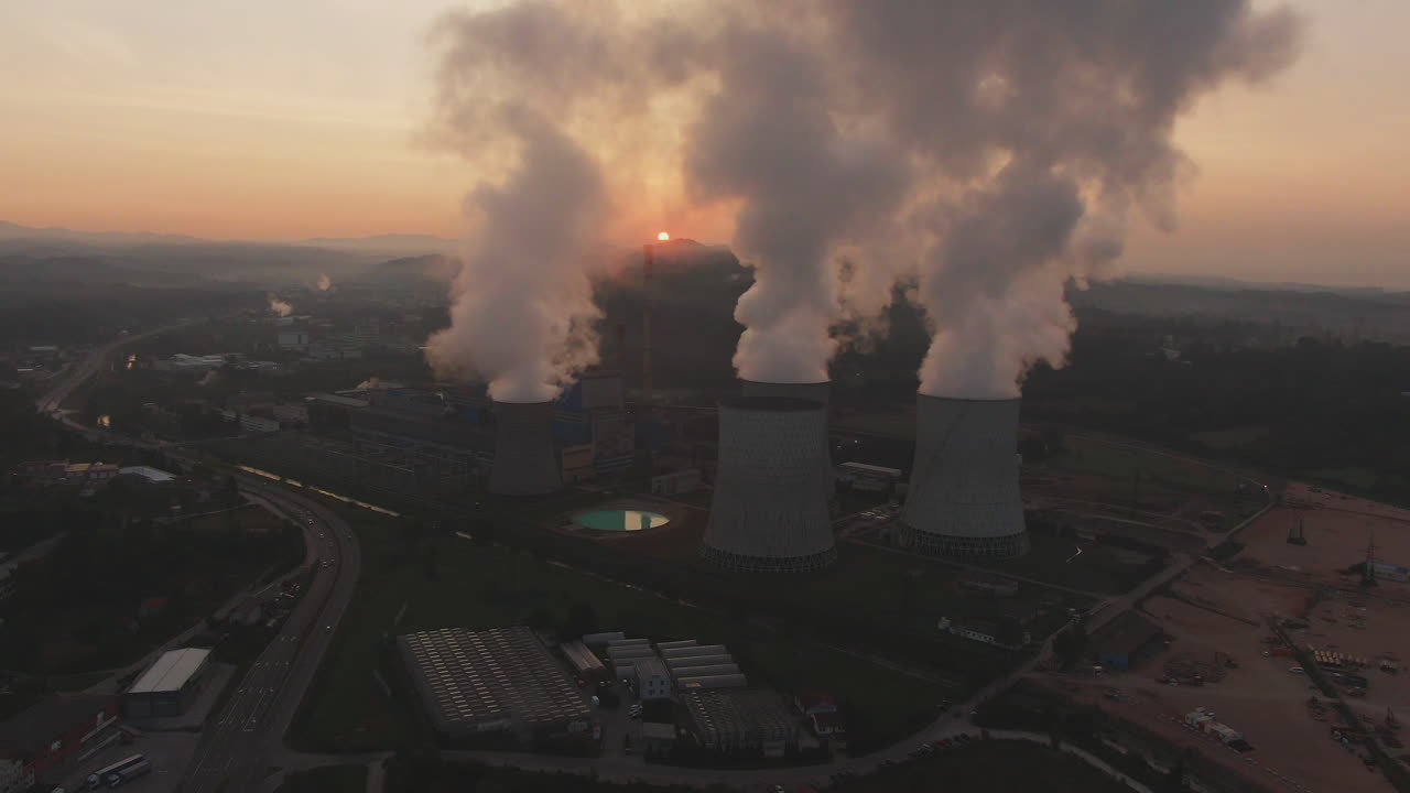 Power Plant Cooling Towers Emitting Smoke at Sunset