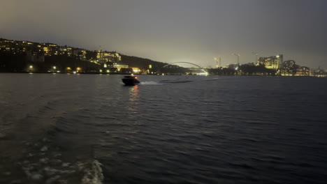 viajar en barco en el mar durante la noche mientras un barco más pequeño cruza detrás