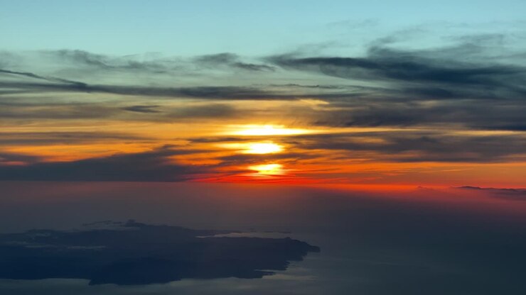 Splendido tramonto rosso vicino all'isola di Ibiza, Spagna, registrato dalla cabina di pilotaggio di un jet in volo verso ovest a 7000 metri di altezza.