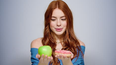 Thoughtful-girl-making-a-decision-in-studio.-Woman-choosing-doughnut-indoors