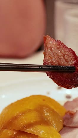 chopsticks holding food over a plate