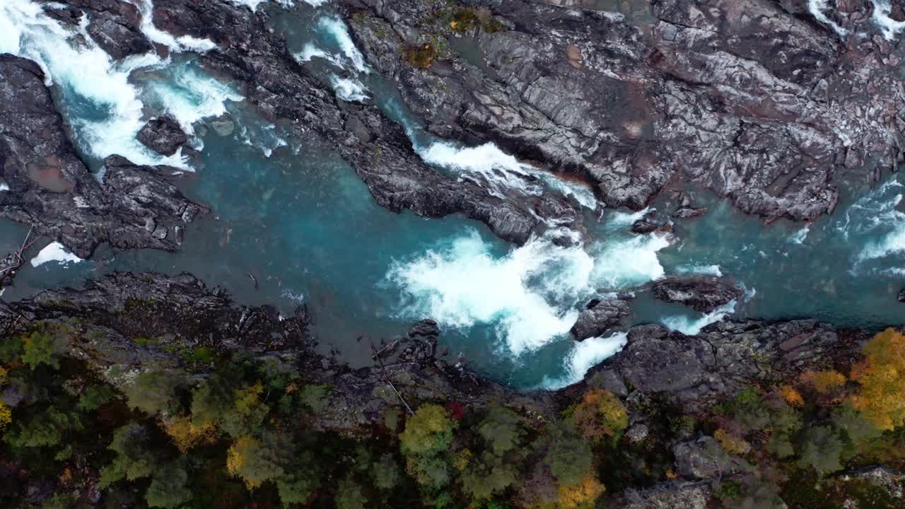 Vista dall'alto di montagne aspre con un fiume impetuoso nel Parco Nazionale di Dovrefjell, Norvegia orientale