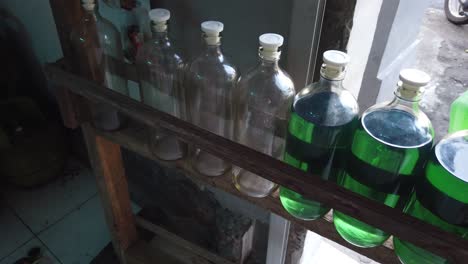 gas petrol station in asia, blue oil stored in glass bottles, indonesia bali southeast asian typical shop