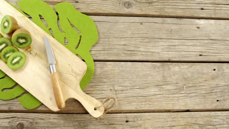 Slices-and-half-section-of-kiwi-on-chopping-board