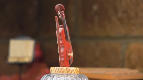 fotografía de cerca de un instrumento musical en miniatura, el violín, girando en su lugar como decoración