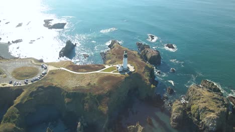 overhead aerial view of the yaquina head lighthouse surrounded by blue water in newport, oregon