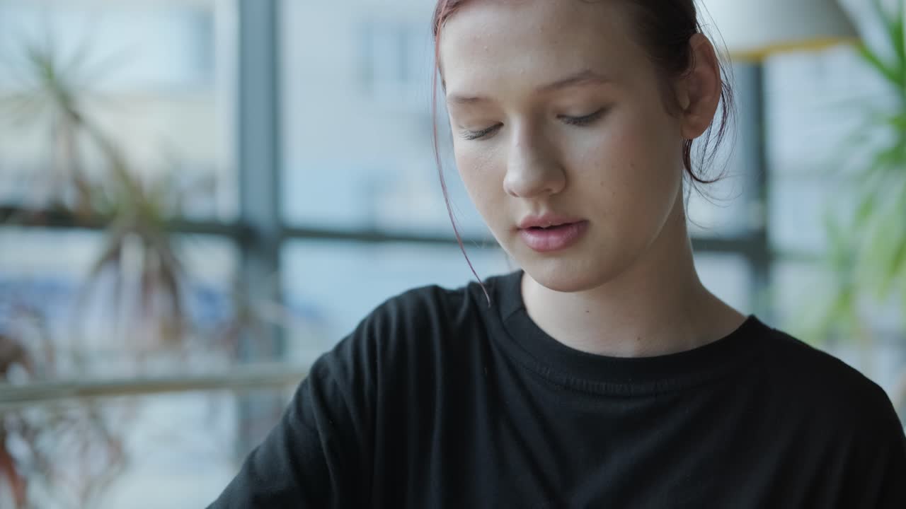 un adolescente bebiendo agua en un café