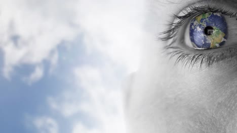 globe over close up of female eye against clouds in blue sky