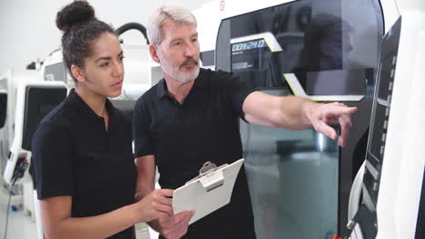 aprendizaje femenino trabajando con un ingeniero en máquinas cnc