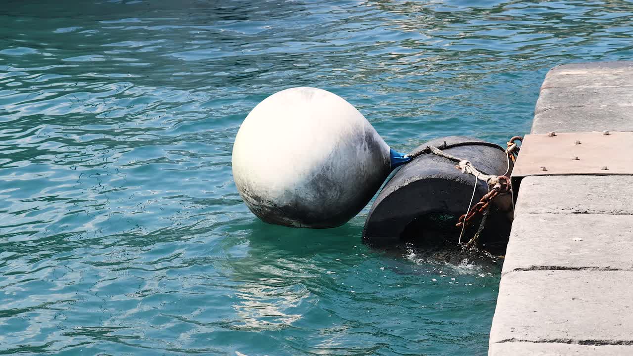 Buoy bobbing in water near pier