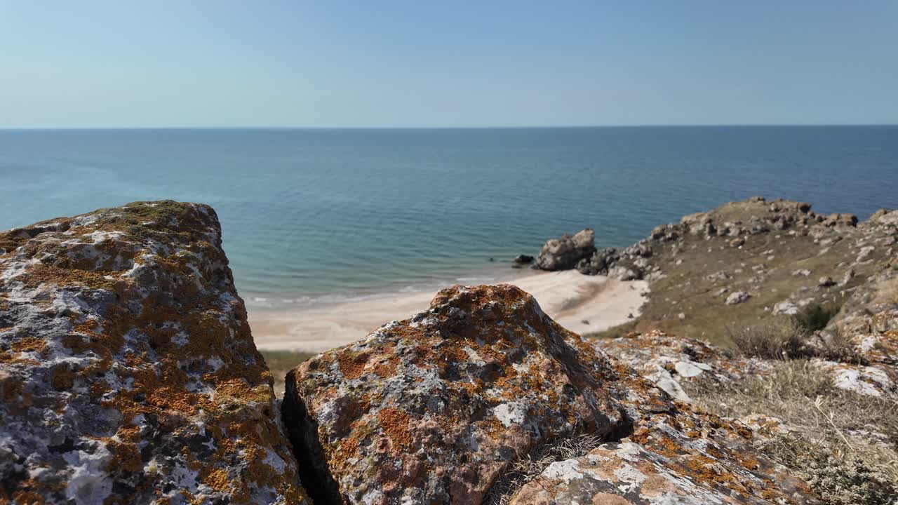 Rocky Coastal View with Sandy Beach and Blue Sea