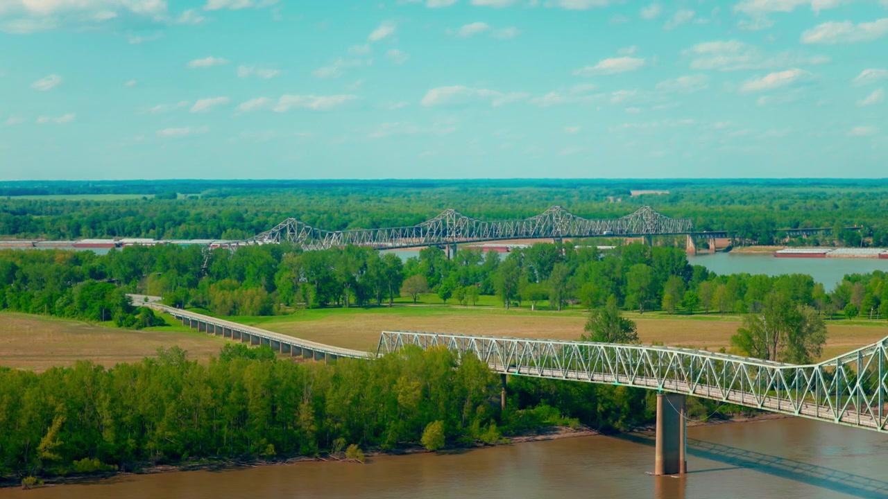 Cairo, Illinois, dove convergono i fiumi Ohio e Mississippi, un punto di riferimento geografico storico tristatale incorniciato da ponti di ferro e una lussureggiante pianura alluvionale estiva.