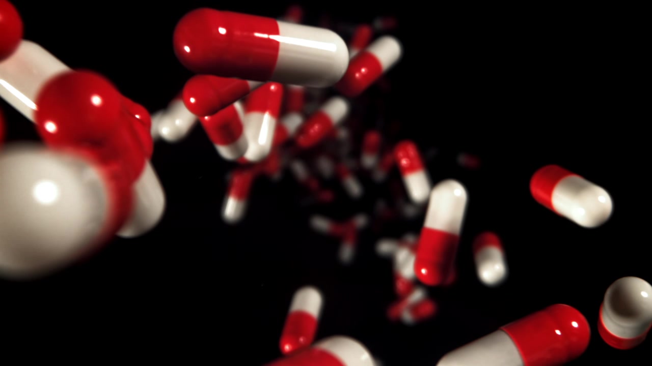 Capsule mediche rosse e bianche galleggianti su sfondo nero