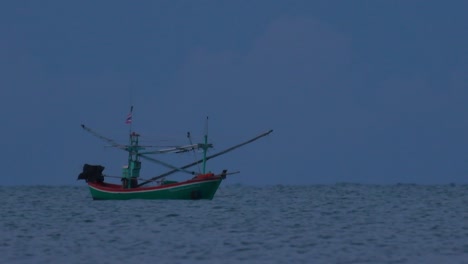 los barcos de pesca en tailandia esperan en medio del océano a que oscurezca para poder encender sus luces verdes y comenzar a pescar y pescar camarones