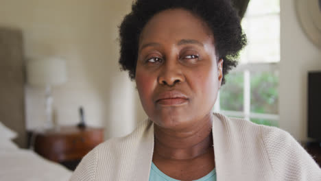 Thoughtful-african-american-senior-woman-sitting-on-the-bed-at-home