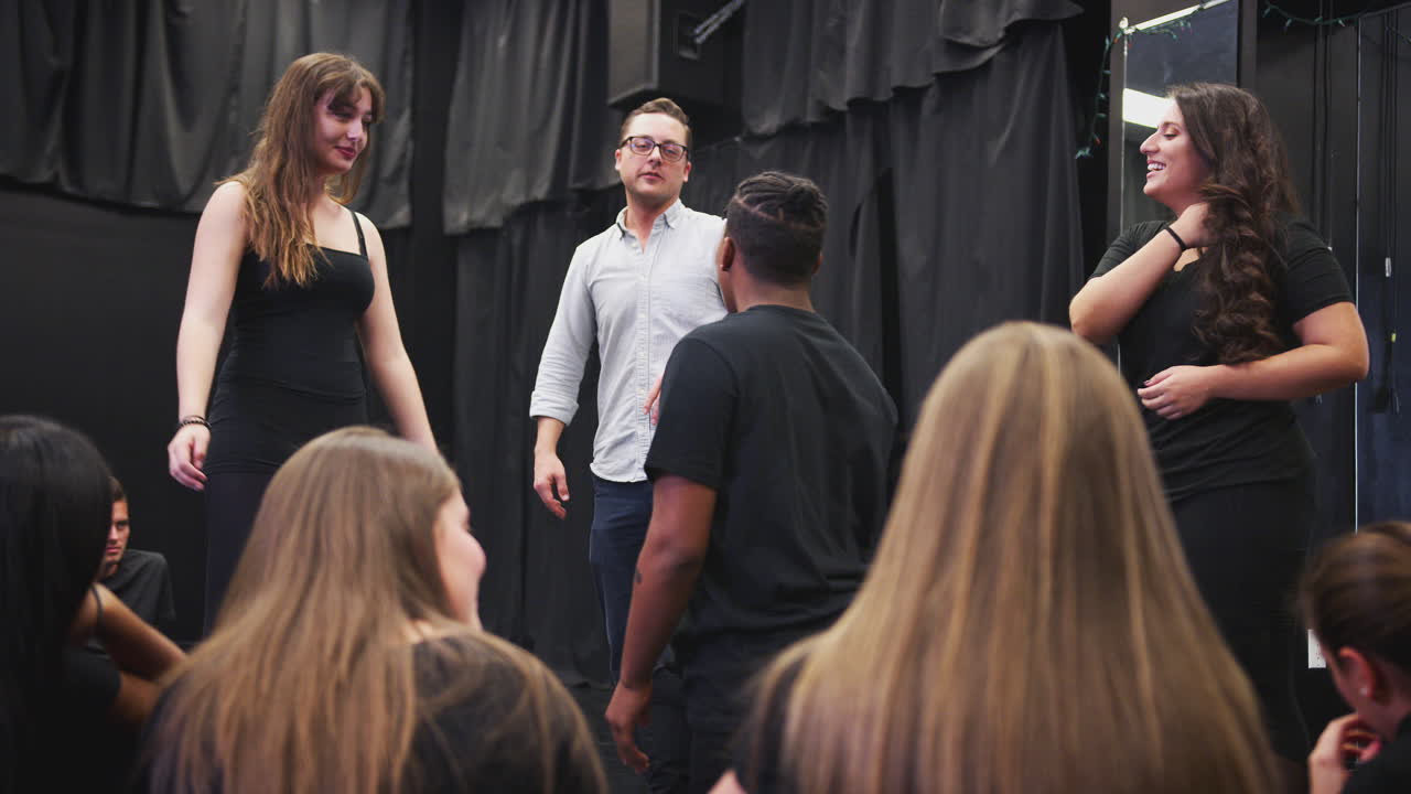 maestro con estudiantes de teatro en la escuela de artes escénicas en la clase de improvisación de estudio