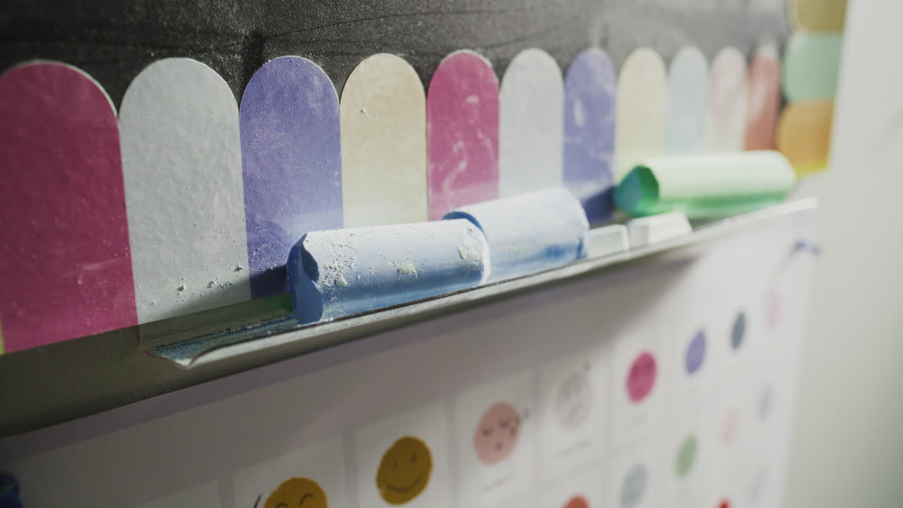 Close Up of Colorful Chalks for Drawing or Writing Lying on Blackboard in Classroom