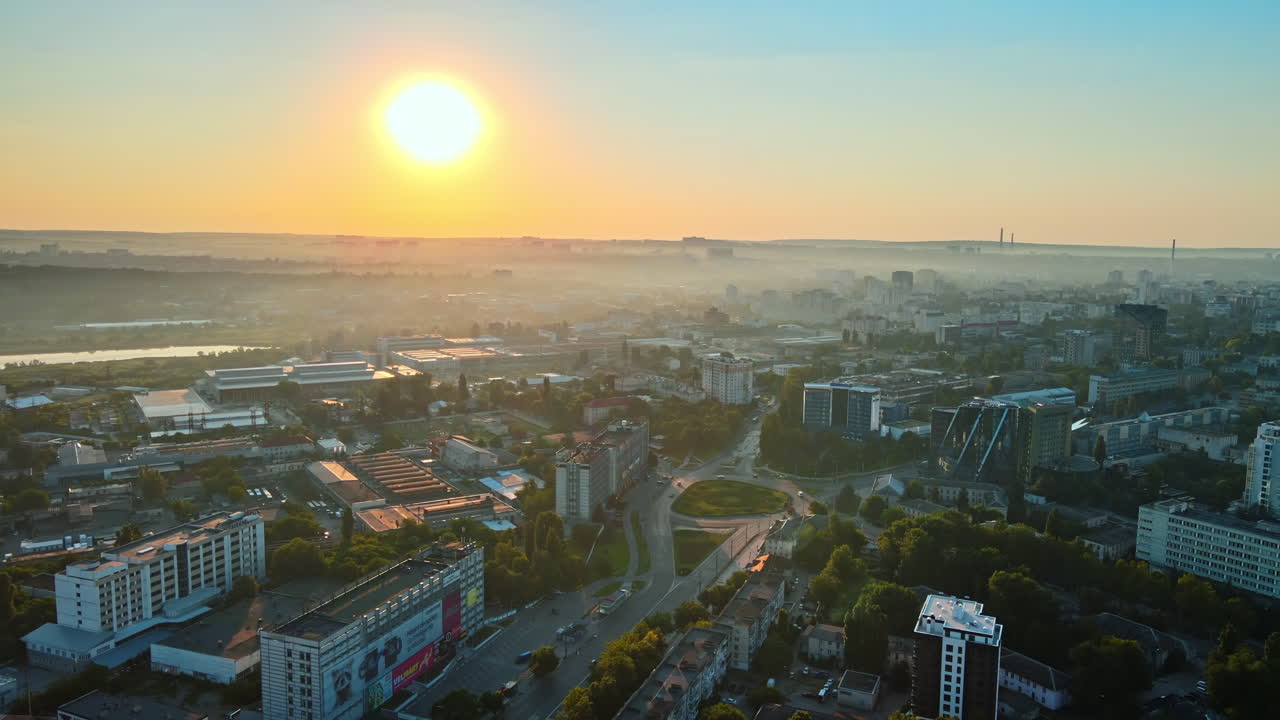 Aerial drone view of Chisinau at sunrise. Multiple buildings, trees, parks, roads with cars. Moldova