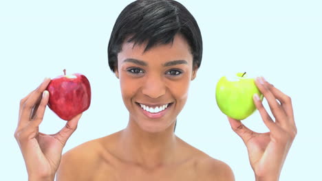 mujer sonriente sosteniendo dos manzanas