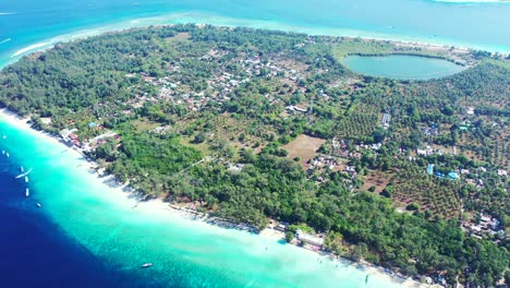 Insel-In-Indonesien-–-Tropisches-Paradies-Mit-Lagune-Und-Grünen-Bäumen,-Umgeben-Von-Strahlend-Blauem-Meerwasser-–-Ein-Perfektes-Touristenziel-–-Luftaufnahme