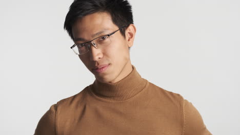 hombre asiático con gafas mirando a la cámara.