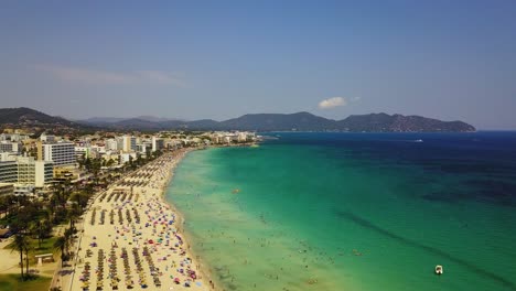 Drone-slowly-approaching-the-whole-stretch-of-the-Cala-Mayor-coastline,-a-tourist-destination-in-Palma-de-Mallorca-a-Mediterranean-island-off-the-coast-of-Spain