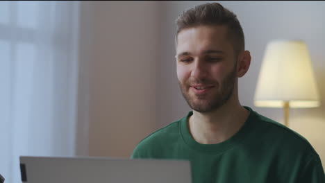 Un-Hombre-Alegre-Y-Sonriente-Saluda-A-Los-Participantes-De-Un-Video-Chat-En-Línea-Saludando-Con-La-Mano-Al-Retrato-Masculino-De-Una-Cámara-Web-En-Una-Reunión-De-Trabajo-Distante-En-La-Sala-De-Estar