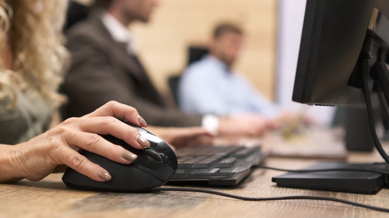 Crop mature businesswoman using computer mouse on desk in office