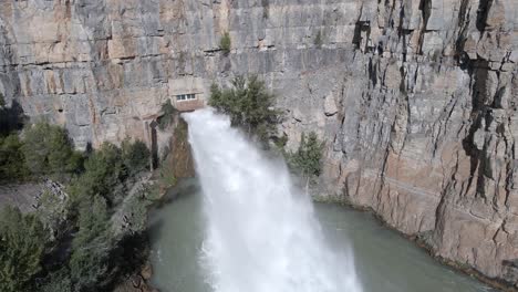 powerful water jet splash from el chorro drainage point of arenos reservoir, aerial