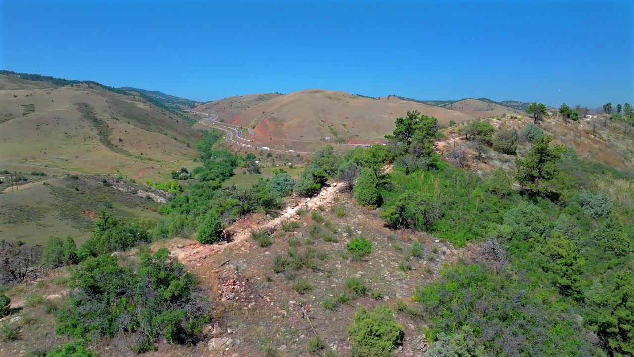 Mountain Biking downhill sport fitness Red Rocks Morrison Golden Colorado aerial drone i70 highway Dinosaur ridge Dakota Ridge Trail Denver foothills front range adult male biker sunny blue sky day