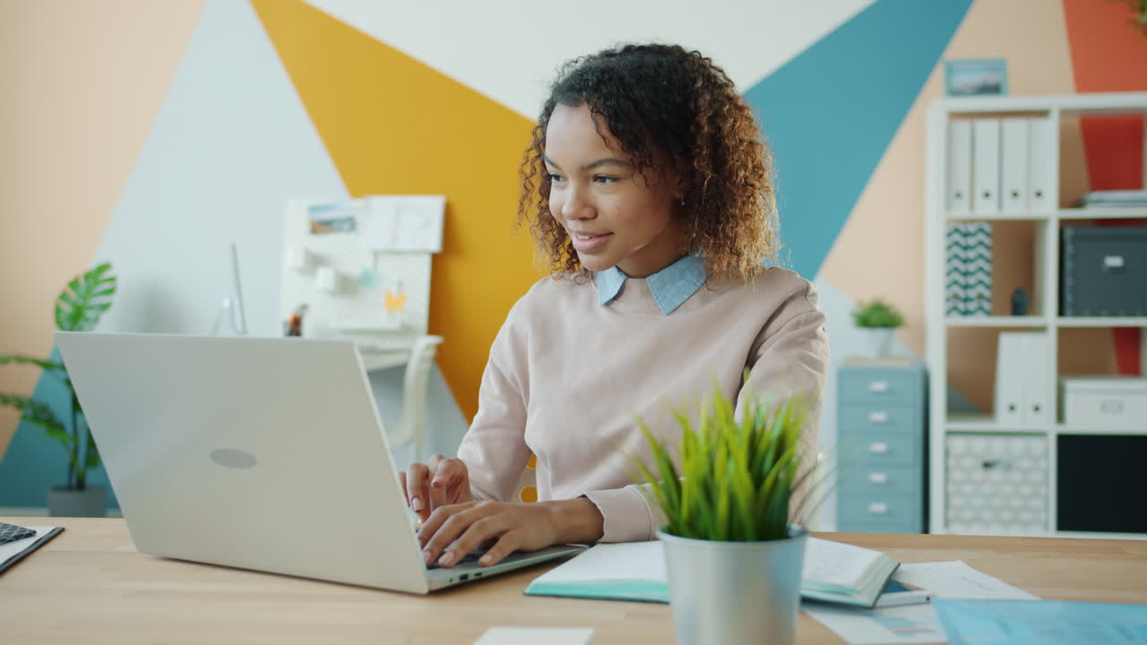 Young Woman Working on Laptop in Modern Office