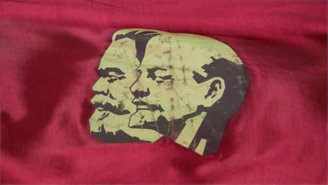 Close-up-of-a-stylized-portrait-of-Marx-and-Lenin-on-a-red-satin-parade-banner-of-the-Soviet-Union
