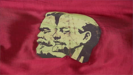 close-up of a stylized portrait of marx and lenin on a red satin parade banner of the soviet union