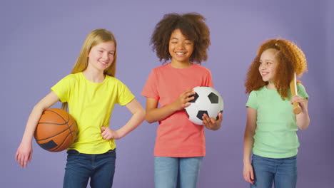 Studioaufnahme-Von-Kindern-Mit-Sportgeräten-Für-Fußball,-Basketball,-Baseball-Auf-Violettem-Hintergrund