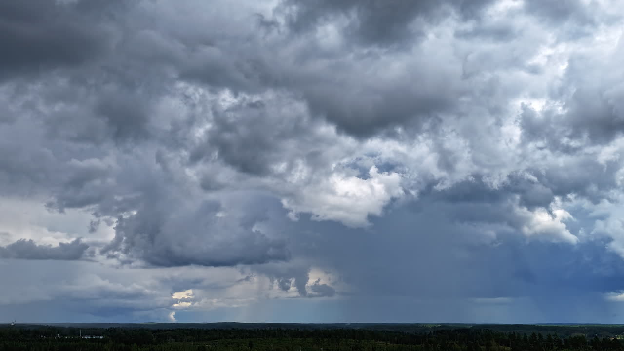 Hyperlapse drone shot of storm and rain clouds above forest on the countyside