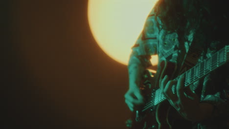 young guitaring performing music concert in dark studio