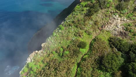 drone shot of a young, fit and strong man hiking up espigao amorelo on maderia during the summer