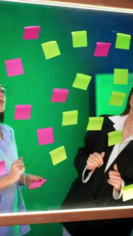 office employees putting stickers on the glass board. preparation for brainstorming or business presentation. vertical video.