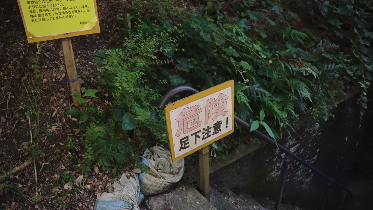 Japanese sign saying Danger before staircase to Tomogashima Tunnels, Japan