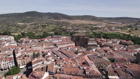 avance lento aéreo sobre el centro de la ciudad de plasencia, vasto paisaje de fondo, españa