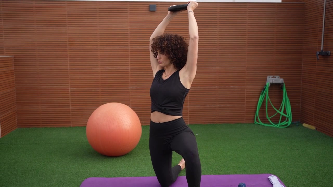 A woman exercising with weights in a contemporary gym setting with modern equipment