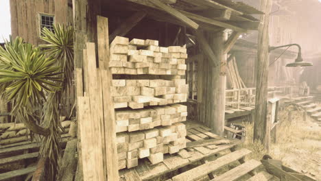wooden planks stacked outside a rustic structure in an arid landscape