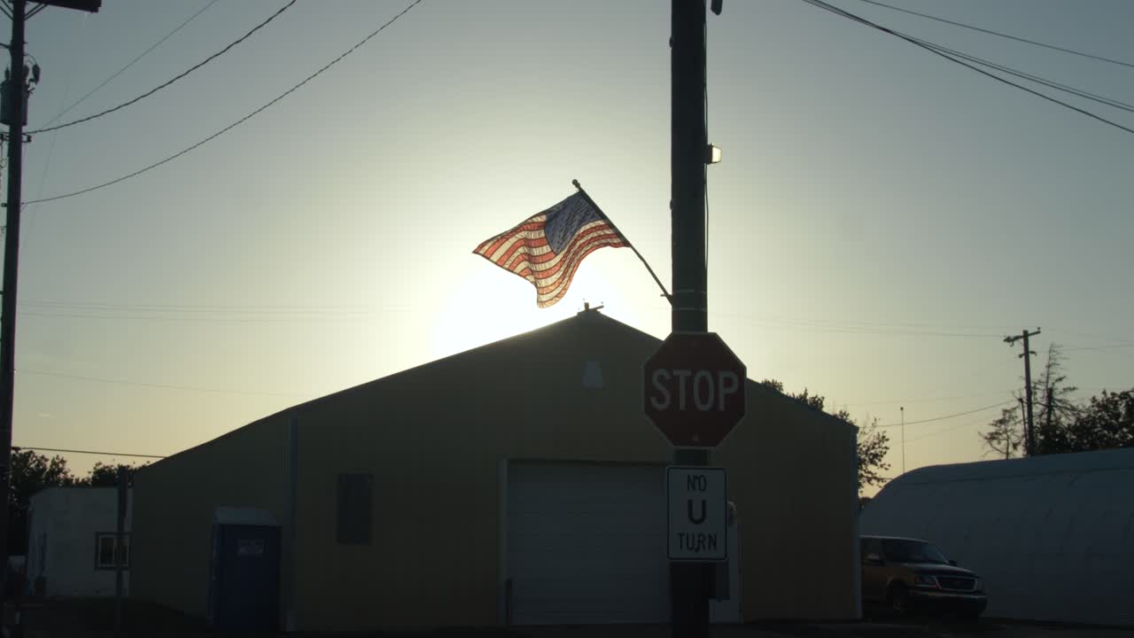 bandera estadounidense volando para el 4 de julio en la puesta de sol en cámara lenta cinematográfica