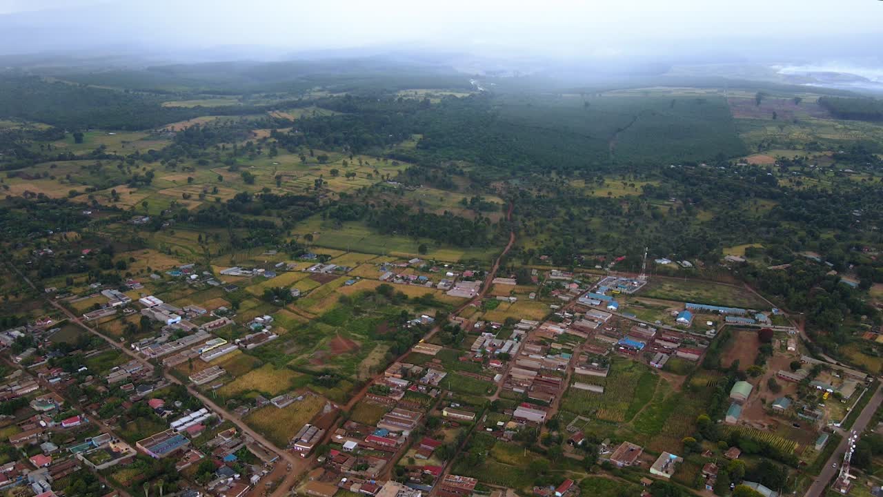 vista aérea de la lluvia moviéndose hacia un pueblo rural en kenia - disparo de dron descendente