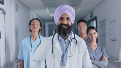 portrait of diverse doctors and nurses smiling in corridor at hospital, in slow motion