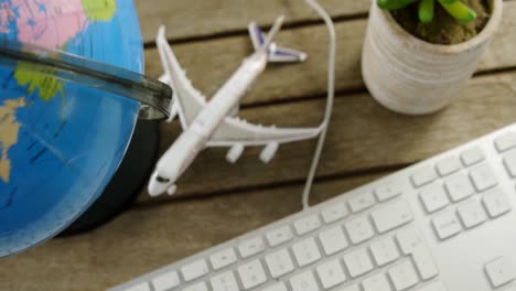 keyboard, airplane model and globe on table 4k