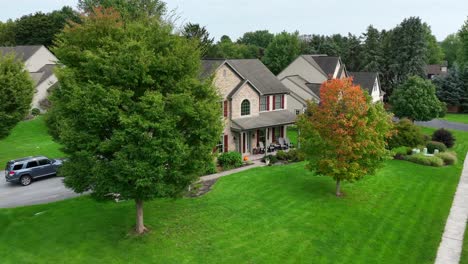 traditional two story colonial stone house with red shutters in america in autumn