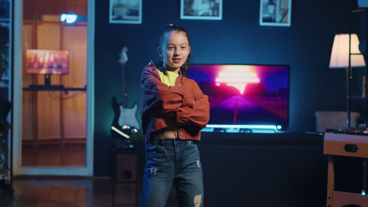 밝지 않은 개인 스튜디오에서 인터넷 시청자를 위해 댄스 비디오를 녹화하는 즐거운 소녀